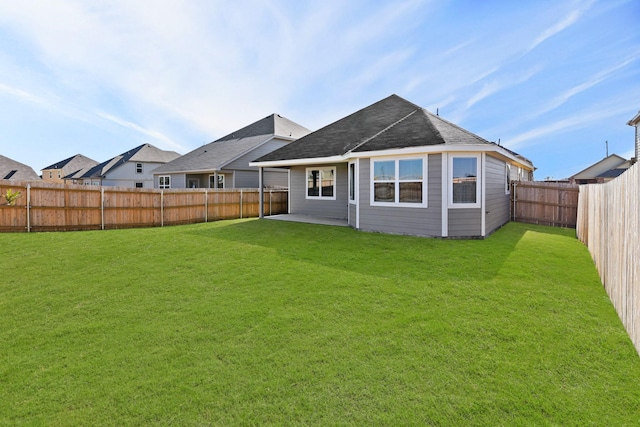 rear view of property with a lawn and a fenced backyard