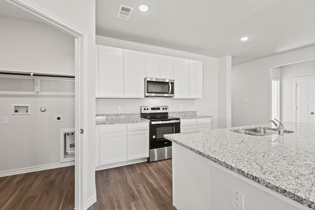 kitchen with stainless steel appliances, white cabinets, a sink, and light stone countertops