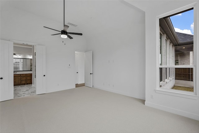 carpeted spare room with ceiling fan and lofted ceiling