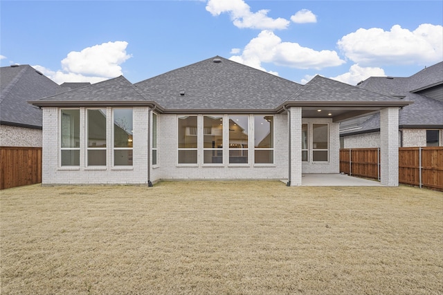 rear view of property featuring a patio and a yard