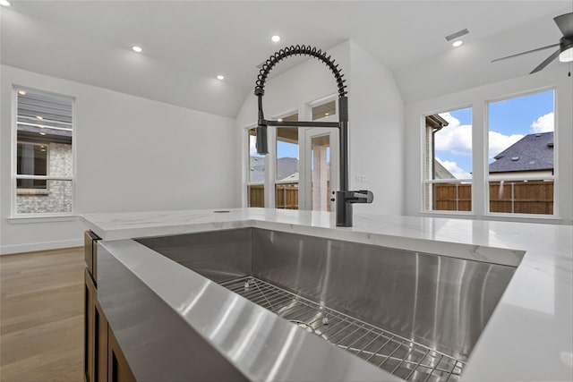 details with ceiling fan, light stone countertops, hardwood / wood-style floors, and sink