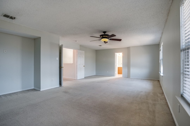 unfurnished room with carpet, ceiling fan, and a textured ceiling