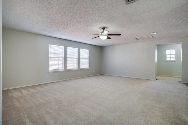 spare room featuring a textured ceiling, carpet, and ceiling fan