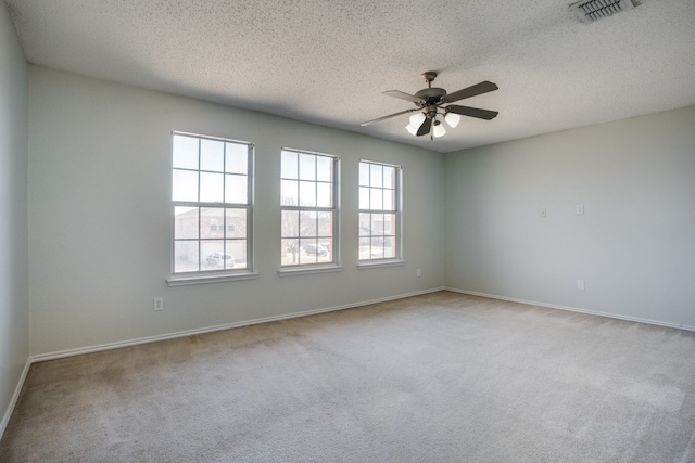 carpeted empty room featuring a textured ceiling and ceiling fan