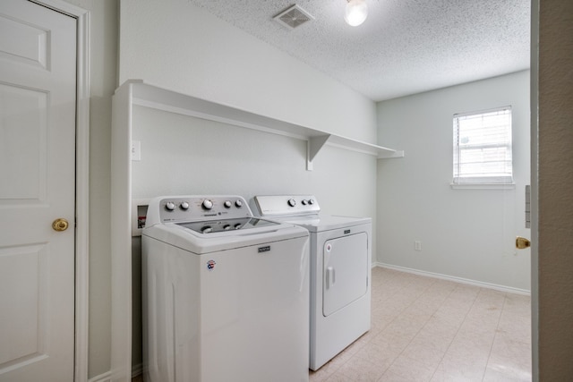 laundry room featuring hookup for a washing machine, washing machine and clothes dryer, a textured ceiling, and light tile flooring