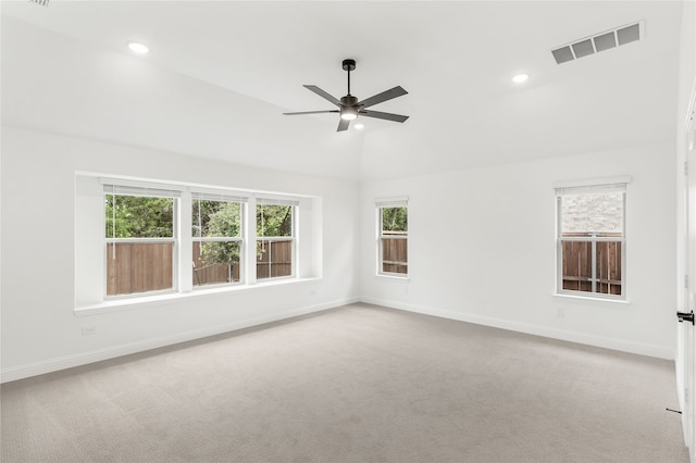 empty room featuring ceiling fan, lofted ceiling, and light carpet