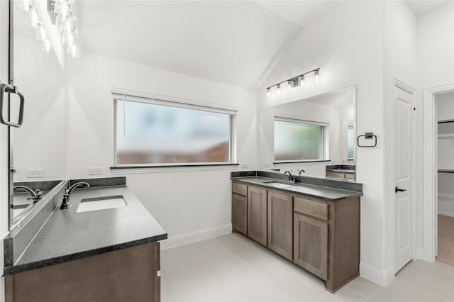 bathroom with lofted ceiling, tile patterned flooring, and vanity