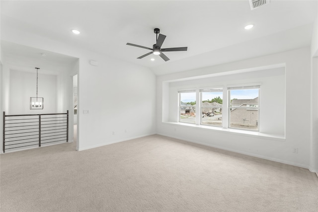 carpeted empty room with ceiling fan with notable chandelier