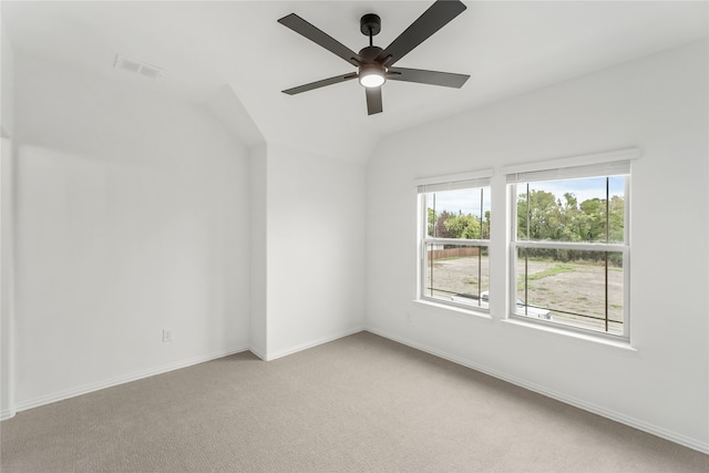 carpeted spare room with ceiling fan and vaulted ceiling