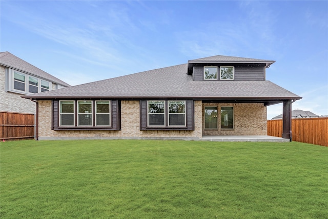 back of house with a patio and a lawn