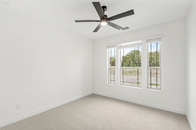 empty room featuring ceiling fan and carpet