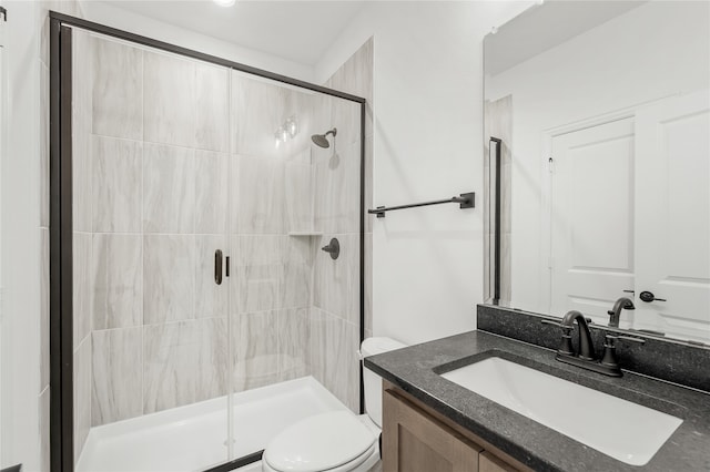 bathroom featuring vanity, toilet, and an enclosed shower