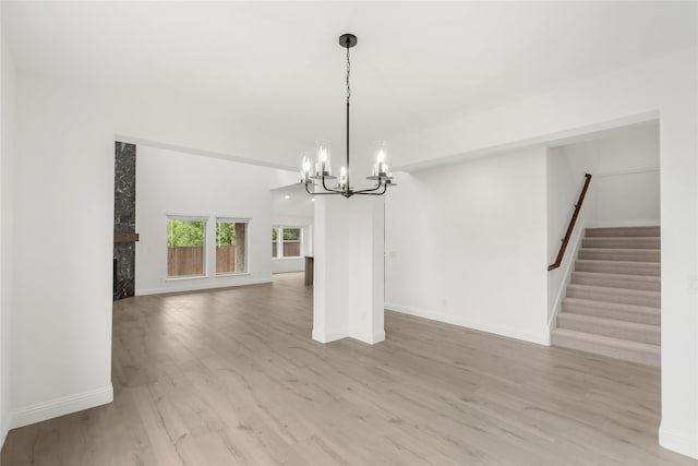 unfurnished dining area featuring an inviting chandelier and light hardwood / wood-style flooring