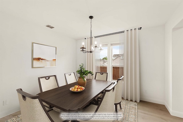 dining space featuring an inviting chandelier and light hardwood / wood-style floors