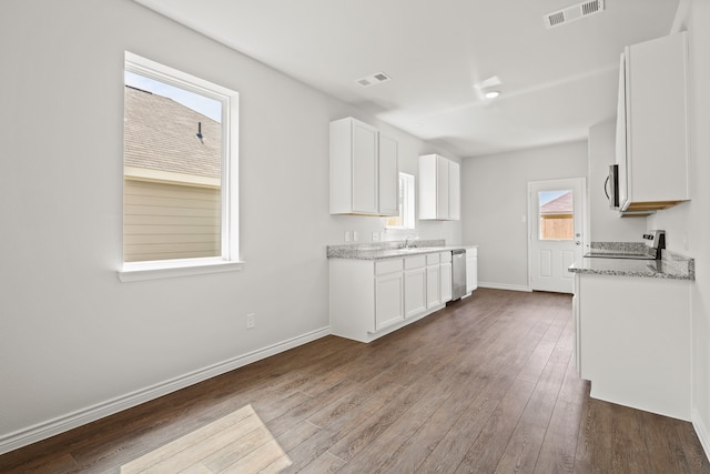 kitchen with light stone counters, wood-type flooring, white cabinetry, and stainless steel appliances