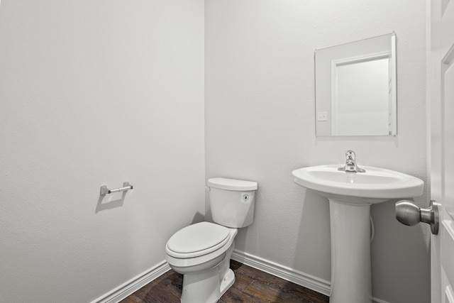 bathroom with hardwood / wood-style floors and toilet