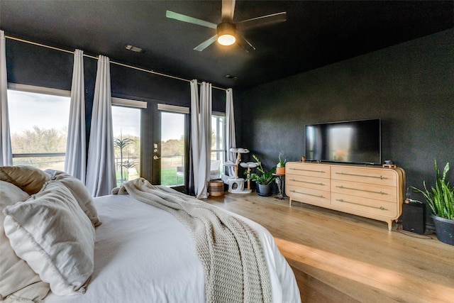 bedroom featuring hardwood / wood-style flooring, ceiling fan, and french doors