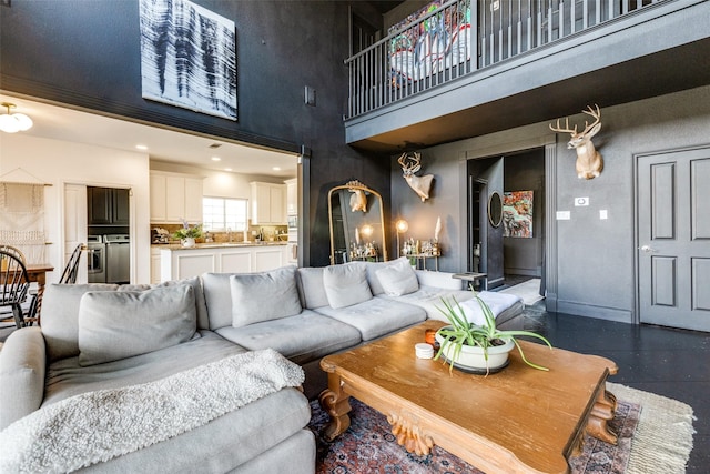 living room featuring a towering ceiling and sink