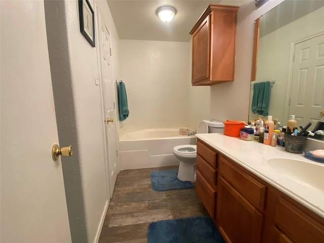 bathroom with toilet, a bathtub, vanity, and hardwood / wood-style flooring