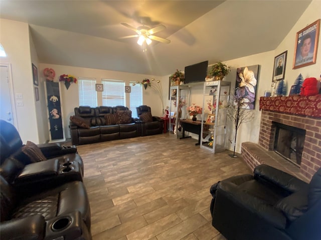 living room with hardwood / wood-style floors, ceiling fan, a fireplace, and vaulted ceiling