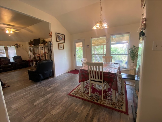 dining room featuring plenty of natural light, ceiling fan with notable chandelier, dark wood-type flooring, and vaulted ceiling