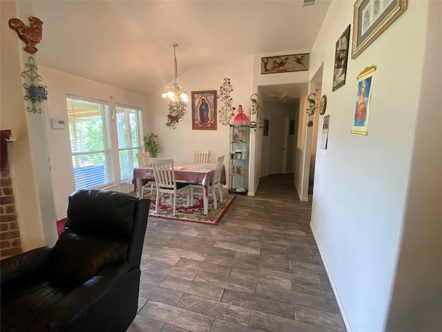 dining area with a notable chandelier and lofted ceiling