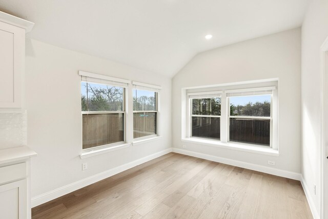 interior space featuring light wood-type flooring and vaulted ceiling