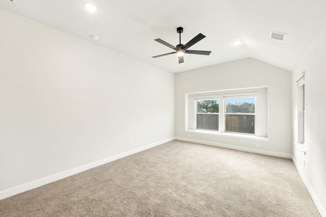 carpeted empty room featuring vaulted ceiling and ceiling fan