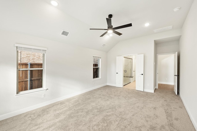 unfurnished bedroom featuring light carpet, vaulted ceiling, and ceiling fan