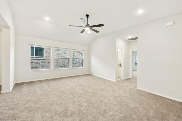 unfurnished room with light colored carpet, vaulted ceiling, and ceiling fan