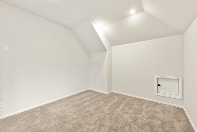 bonus room with light carpet and vaulted ceiling