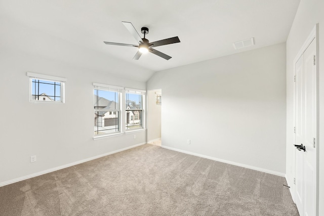 carpeted empty room featuring ceiling fan and vaulted ceiling