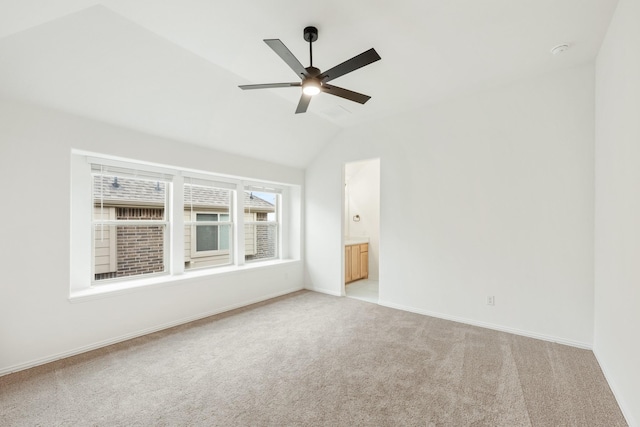 carpeted empty room with ceiling fan and lofted ceiling