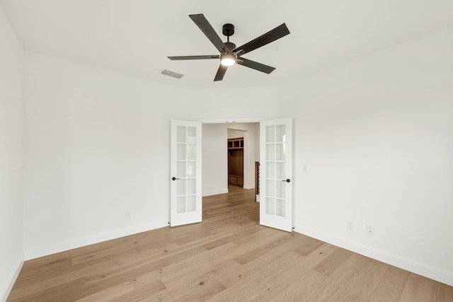 spare room featuring french doors, ceiling fan, and light wood-type flooring