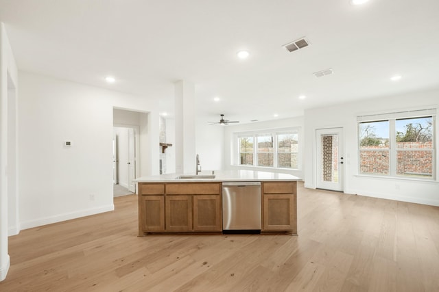 kitchen featuring a wealth of natural light, ceiling fan, dishwasher, sink, and light wood-type flooring