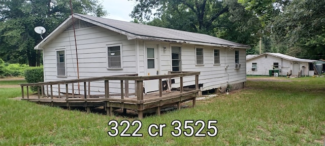 rear view of property featuring a deck and a yard