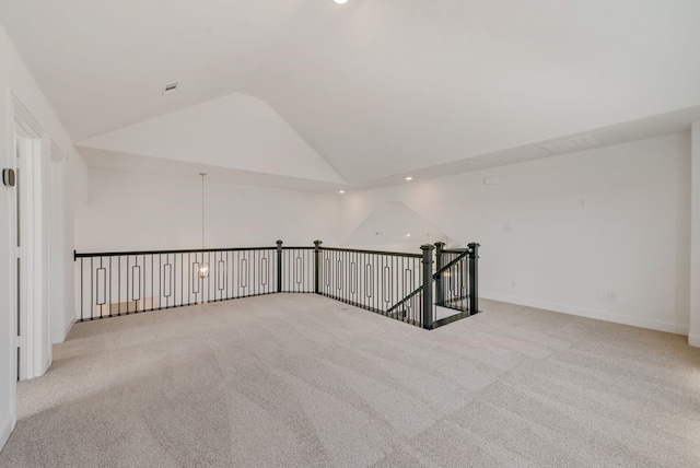 carpeted empty room featuring lofted ceiling