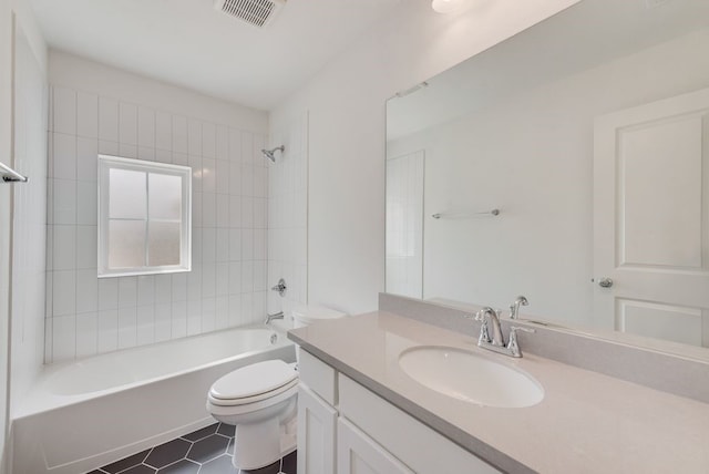 full bathroom with toilet, tiled shower / bath, vanity, and tile patterned floors