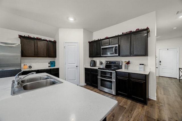 kitchen with dark hardwood / wood-style floors, sink, dark brown cabinetry, and stainless steel appliances