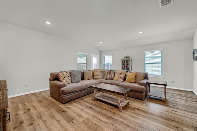 living room with light wood-type flooring and vaulted ceiling