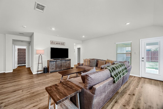 living room featuring light wood-type flooring and vaulted ceiling