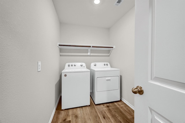 washroom with light hardwood / wood-style flooring and independent washer and dryer