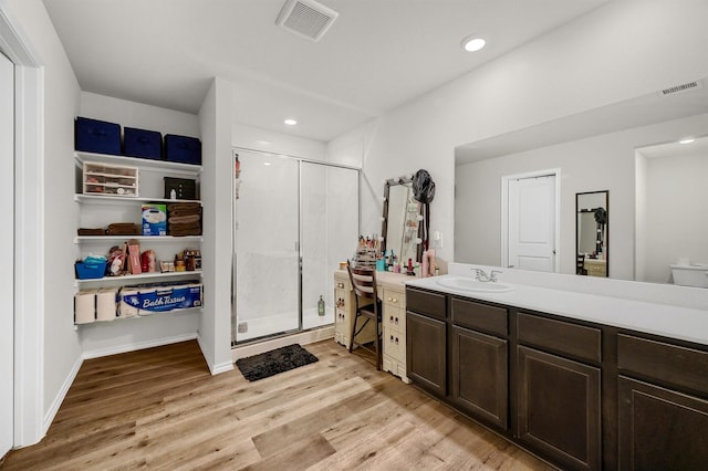 bathroom with vanity, wood-type flooring, and a shower with door