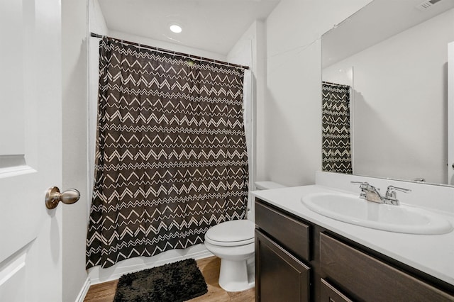 bathroom featuring walk in shower, hardwood / wood-style floors, vanity, and toilet