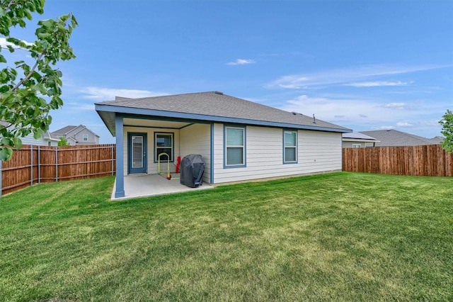 rear view of property featuring a lawn and a patio