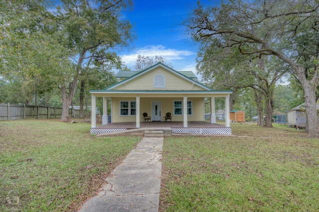 view of front of property featuring a front lawn, covered porch, and a storage unit