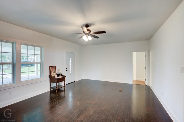 spare room with ceiling fan and dark hardwood / wood-style flooring