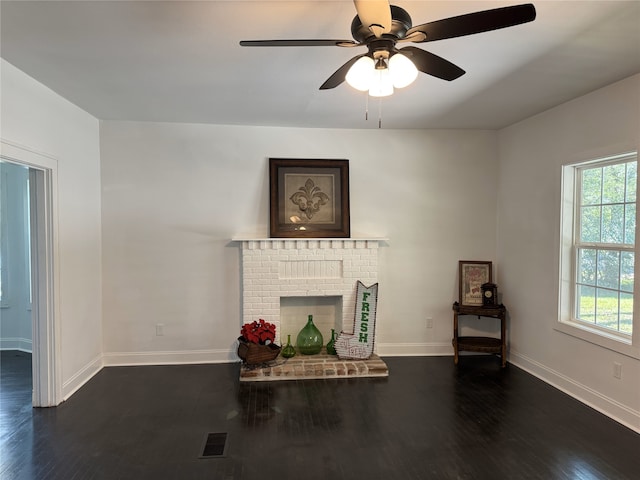 living room with ceiling fan, dark hardwood / wood-style flooring, and a brick fireplace