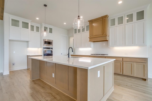 kitchen with light wood-type flooring, a spacious island, sink, and tasteful backsplash