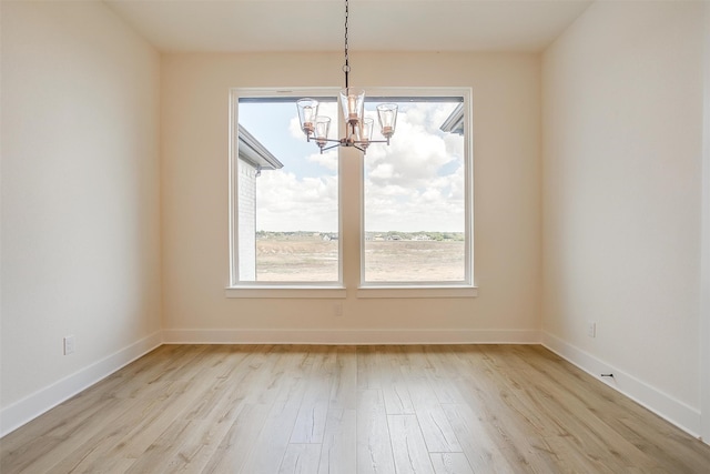 unfurnished dining area with light hardwood / wood-style flooring and a chandelier